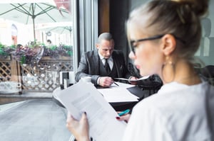 beautiful-young-woman-checking-documents-caf